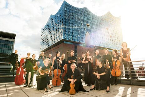 L'Ensemble Resonanz è visibile davanti alla Elbphilharmonie di Amburgo. I musicisti possono essere visti suonare i loro strumenti all'aperto.